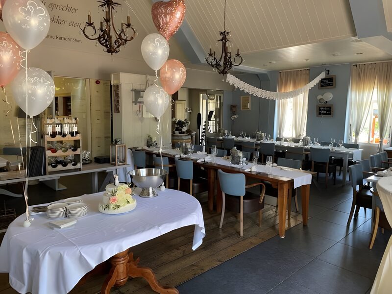 Lange gedekte tafel met bruidstaart in het restaurant