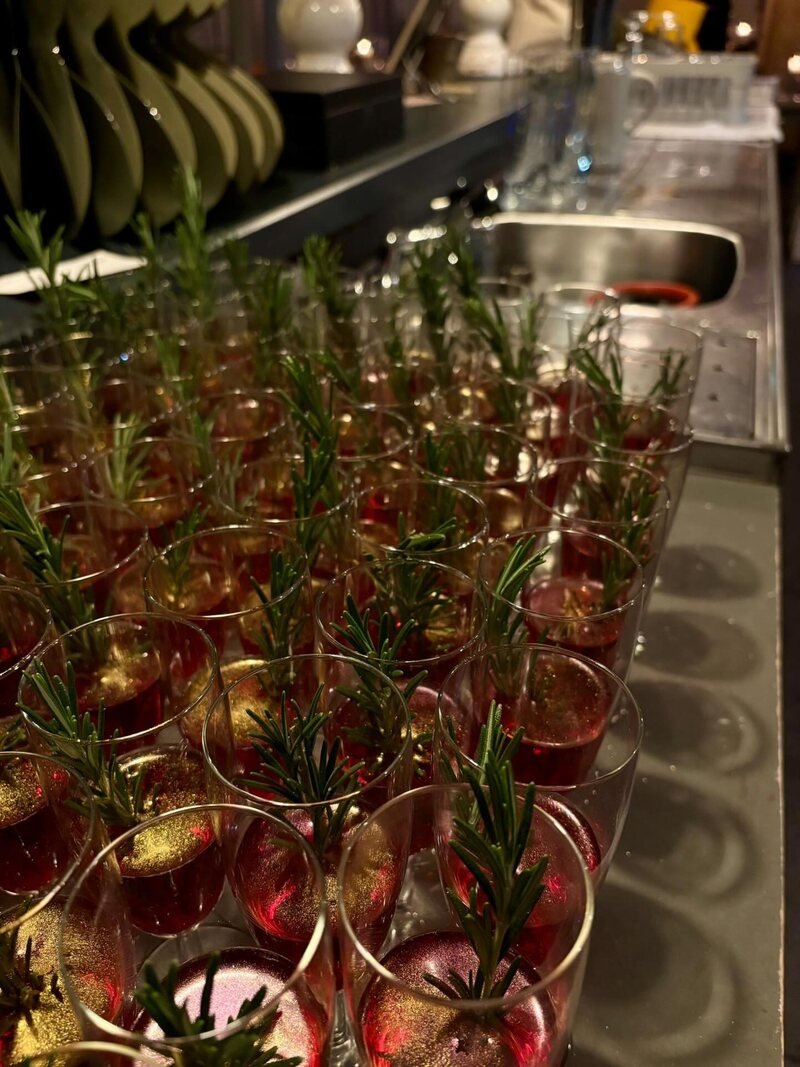 Glazen met een takje rozemarijn, klaargezet op de bar